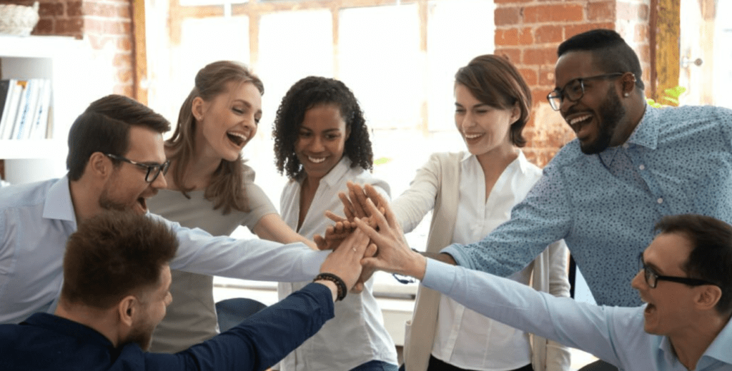 A team of Unsung Heroes in the Accounting and HR departments exchanging high fives in an office.