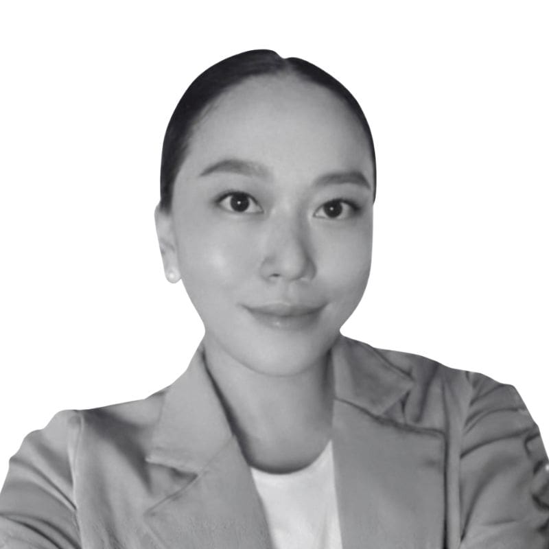 Smiling woman in blazer, plain background