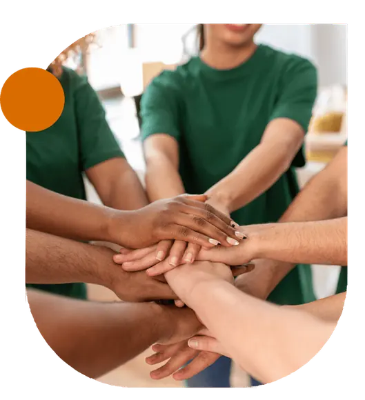 Hands of a diverse nonprofit team stacked together to symbolize collaboration and shared purpose.